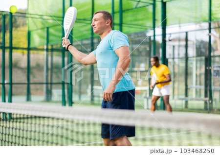 Male padel tennis player training on court Male padel tennis player training on court 103468250