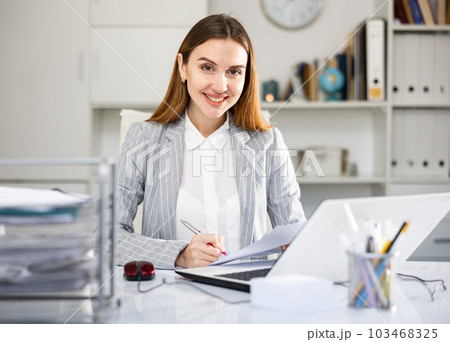 Portrait of young woman office worker sitting at table 103468325