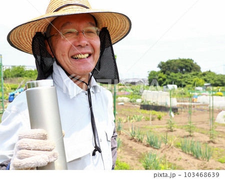 畑で水分補給するシニア男性 103468639