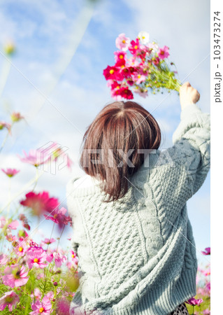 コスモス畑で花束を持って立つ女性 103473274