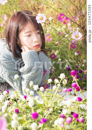 コスモス畑でポーズをとる女性 103473395
