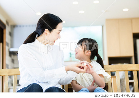 娘に絆創膏を貼る母親 103474635