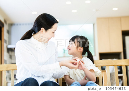 娘に絆創膏を貼る母親 103474638