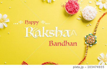 Raksha Bandhan, Indian festival with beautiful Rakhi and Rice Grains on yellow background. A traditional Indian wrist band which is a symbol of love between Sisters and Brothers 103474935
