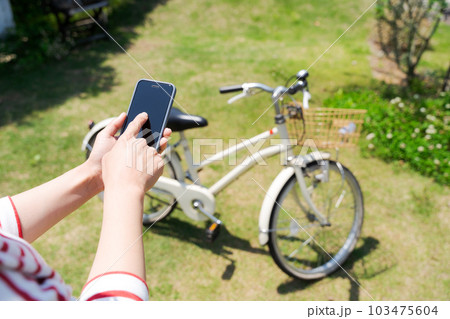 自転車とスマホを操作する女性の手元写真 自転車とスマホを操作する女性の手元写真 103475604
