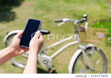 自転車とスマホを操作する女性の手元写真 自転車とスマホを操作する女性の手元写真 103475606