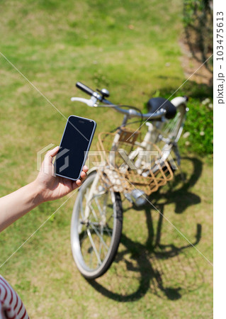 自転車とスマホを操作する女性の手元写真 自転車とスマホを操作する女性の手元写真 103475613