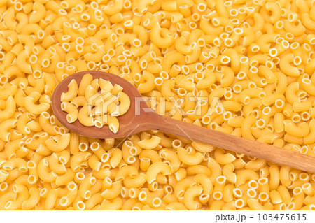 Uncooked Chifferi Rigati Pasta Background with Wooden Spoon Uncooked Chifferi Rigati Pasta Background with Wooden Spoon 103475615