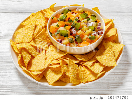 summer fruit salsa with tortilla chips on plate summer fruit salsa with tortilla chips on plate 103475793