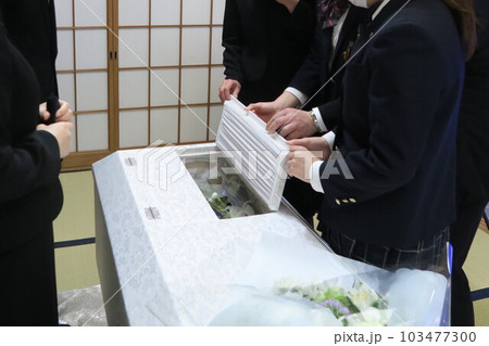棺のふたを閉じる親族 103477300