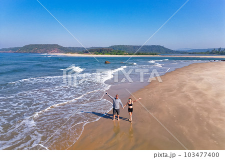 couple walking on beach aerial landscape of coastline and a beach seascape view drone Goa 103477400