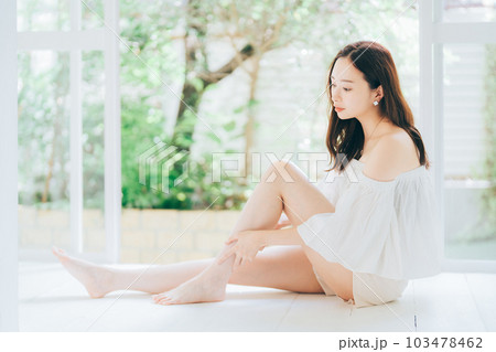 脚のスキンケアとマッサージをする若い女性 103478462