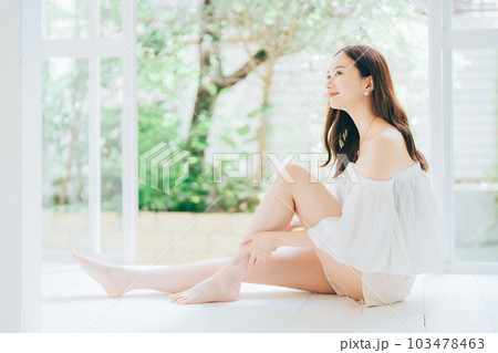 脚のスキンケアとマッサージをする若い女性 103478463