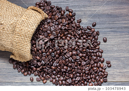 The sack of coffee beans on wooden background The sack of coffee beans on wooden background 103478943