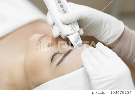 Healthy and radiant skin: thanks to ultrasonic facial cleansing from professional cosmetologist, skin becomes healthy, cleansed toxins and filled natural radiance. Woman in beauty clinic face close-up Healthy and radiant skin: thanks to ultrasonic facial cleansing from professional cosmetologist, skin becomes healthy, cleansed toxins and filled natural radiance. Woman in beauty clinic face close-up 103479154
