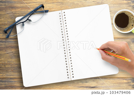 Wood office desk table with notebook, cup of coffee and glasses,flat lay. Wood office desk table with notebook, cup of coffee and glasses,flat lay. 103479406