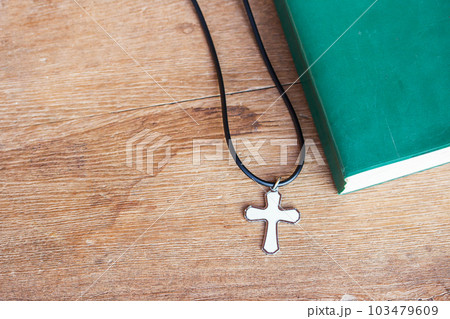 Closeup christian cross and bible on old wooden table with sunlight. Closeup christian cross and bible on old wooden table with sunlight. 103479609