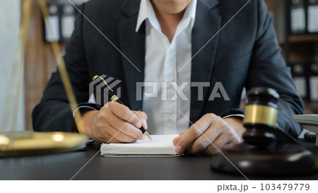 Lawyer in office. Businessmen sitting at desk and making notes. Lawyer in office. Businessmen sitting at desk and making notes. 103479779