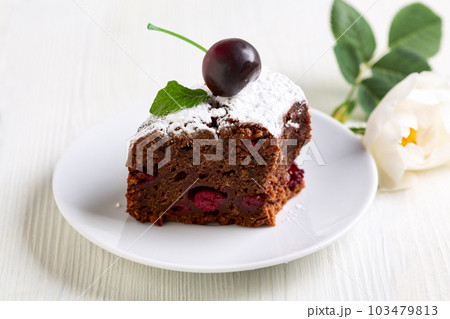Piece of chocolate cake with cherries in close-up. 103479813