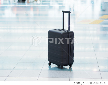 空港の出発ロビーに置かれた黒色のスーツケース 空港の出発ロビーに置かれた黒色のスーツケース 103480403