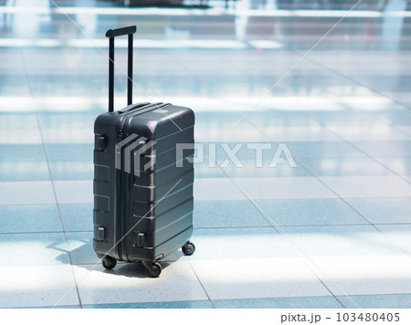 空港の出発ロビーに置かれた黒色のスーツケース 103480405