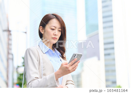 真剣にスマホの画面を見る女性 103481164