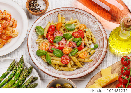 Italian pasta adorned with fresh tomatoes and aromatic basil 103481252