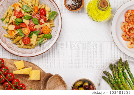 Italian pasta adorned with fresh tomatoes and aromatic basil 103481253