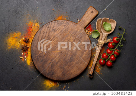 Empty cutting board over various spices Empty cutting board over various spices 103481422