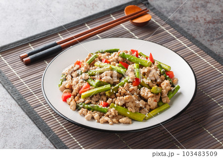 Delicious fried minced pork with asparagus, garlic, chili and sesame close-up in a plate. Horizontal Delicious fried minced pork with asparagus, garlic, chili and sesame close-up in a plate. Horizontal 103483509