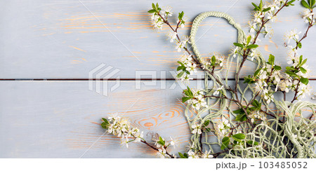 Shopping mesh string bag green with cherry blossom branches on a wooden blue background with a place for your text. Flat lay, top view. Zero waste and plastic free. Shopping mesh string bag green with cherry blossom branches on a wooden blue background with a place for your text. Flat lay, top view. Zero waste and plastic free. 103485052