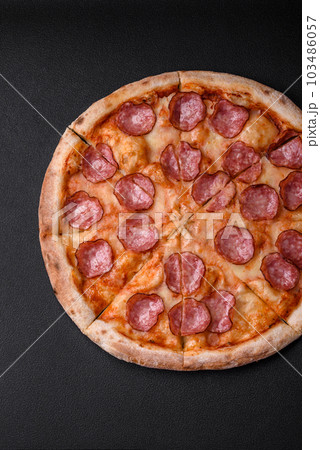 Tasty fresh pizza with salami, cheese, tomatoes, spices and salt 103486057