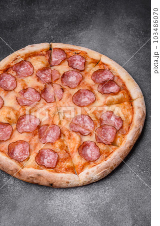 Tasty fresh pizza with salami, cheese, tomatoes, spices and salt 103486070