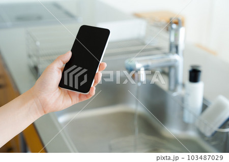 キッチンシンクとスマートフォンを持つ手元写真 キッチンシンクとスマートフォンを持つ手元写真 103487029