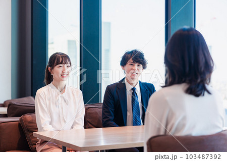 オフィスで雑談をするビジネスパーソン オフィスで雑談をするビジネスパーソン 103487392