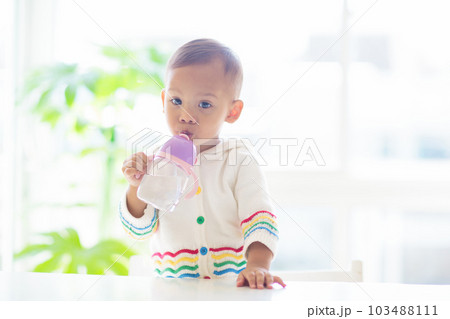 Baby eating solid foods in high chair. Baby eating solid foods in high chair. 103488111