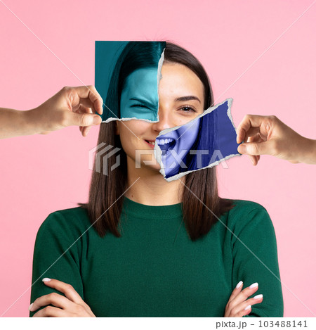 Human hands holding photo face parts with angry and happy expressions. Beautiful young woman and her feelings. Conceptual art collage. 103488141