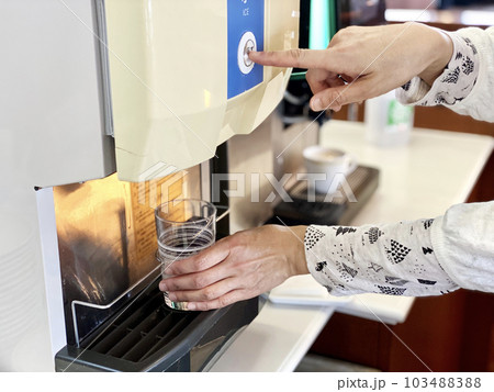 ドリンクサーバーでボタンを押す女性の指 ドリンクサーバーでボタンを押す女性の指 103488388