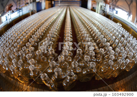 Glassworks. Glass industry. Many glass bottles on a factory conveyor. Glassworks. Glass industry. Many glass bottles on a factory conveyor. 103492900