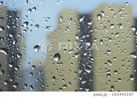 Rain. Raindrops on the window. Rainy day. Blue tone. Drops of water on the glass. Macro shooting. Texture. Concept of autumn weather, background of drops of water rain on glass transparent. 103493197