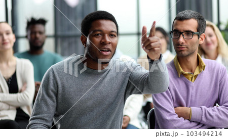 business man raise their hand at the conference to answer a question 103494214