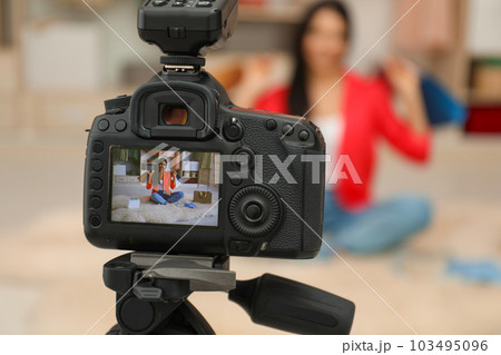Fashion blogger recording new video in room, focus on camera 103495096