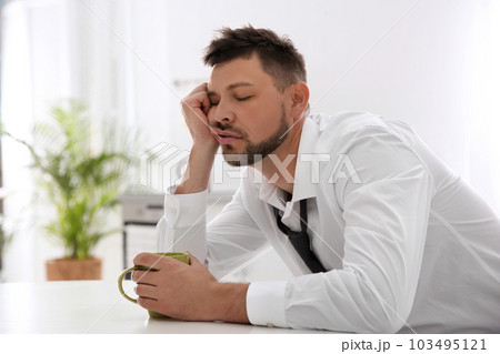 Sleepy man with cup of drink at home in morning Sleepy man with cup of drink at home in morning 103495121