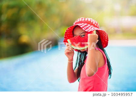 Child with watermelon in swimming pool Child with watermelon in swimming pool 103495957