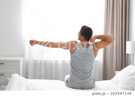 Man awakening on bed at home. Lazy morning 103497149