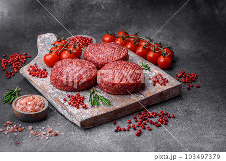 Fresh raw ground beef burger patty with salt and spices 103497379
