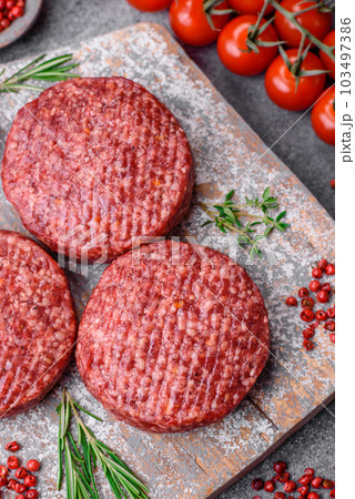 Fresh raw ground beef burger patty with salt and spices 103497386