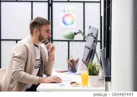 Male designer working at desk in office 103497447