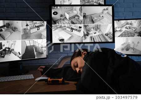 Female security guard sleeping near monitors at workplace 103497579