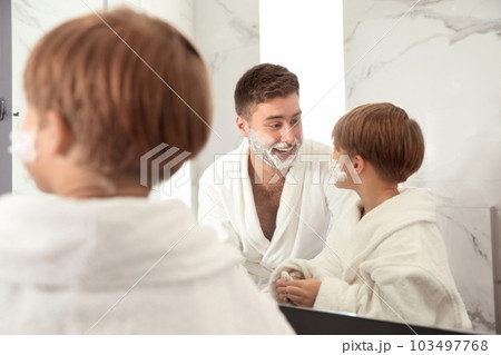Dad and son with shaving foam on faces in bathroom 103497768